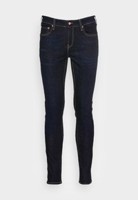Mörkblå denimjeans med slim fit. Har kontrasterande sömmar, fem fickor och en kopparknapp som stängning i midjan.