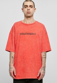 Ülemõõdulise, lühikeste varrukatega T-särk tuhast korallist, millel on must tekst "renaissance." Pehme kangas, mugav lõige ja ümar kaelus.