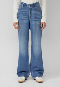 Helle blaue Schlagjeans aus Denim, mit hoher Taille, klassischem Fünf-Taschen-Design und subtilen Verblassungen.