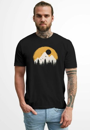 Schwarzes Baumwoll-T-Shirt mit weißem Grafikdruck von Bergen und Wald, gelbe Sonne und schwarzer Kreis, lockere Passform, kurze Ärmel.
