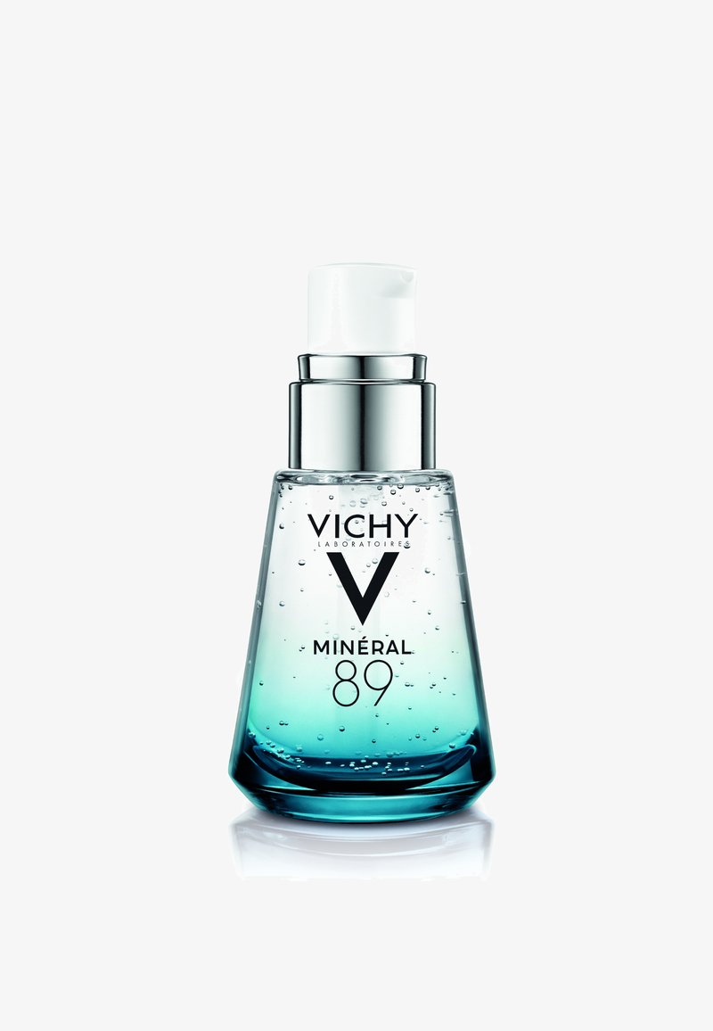 Klare Glas-Pumpflasche mit blau getöntem Serum und Bläschen, beschriftet mit "Vichy Minéral 89" vor weißem Hintergrund.