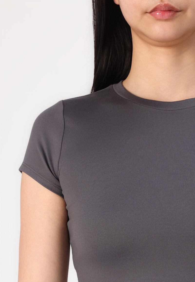 Graues, kurzärmliges, enganliegendes T-Shirt mit Rundhalsausschnitt, glatter Textur und minimalen Nähten an den Ärmeln.