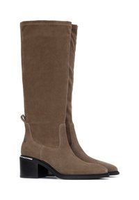Botas de gamuza marrón hasta la rodilla con un tacón cuadrado, que cuentan con una pestaña de agarre para facilitar su uso y costuras sutiles a lo largo de los bordes.