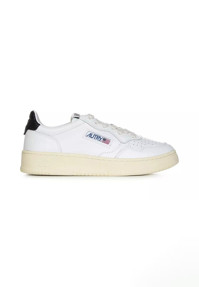 Sneaker in pelle bianca con design perforato, tassello nero sul tallone e suola in gomma beige. Presenta logo ricamato e chiusura con lacci.