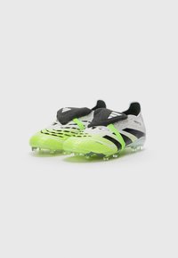Fußballschuhe mit einem strukturierten Obermaterial in Weiß und Neon-Grün, schwarzen Akzenten und einem sockenähnlichen Kragen. Sie verfügen über geformte Nocken für besseren Halt.
