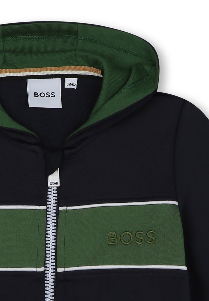 Felpa con cappuccio caratterizzata da un corpo blu navy con un design a righe verdi e bianche. Chiusura con zip e logo ricamato "BOSS" sul petto.