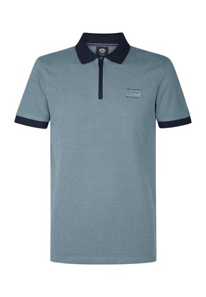Polo shirt in lichtblauw met een gestructureerd patroon. Voorzien van een ritssluiting en een marineblauwe kraag en mouwboorden. Kleine merklabel aan de voorkant.