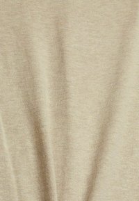 Tissu beige à texture lisse et douce, présentant un léger éclat et un tricot fin. Surface continue et ondulante avec des variations minimes.