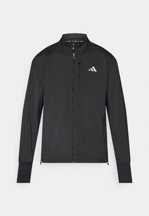 Zwarte sportjack met een hoge kraag, volledige rits, lange mouwen, slim fit en reflecterende logo-details op de borst.