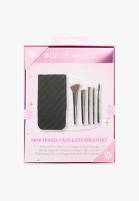 Mini-Reise-Set mit Gesichts- und Augenpinsel, bestehend aus fünf Pinseln mit weichen Borsten und Metallgriffen, verpackt in einem schwarzen, strukturierten Etui, vor einer rosa Box.
