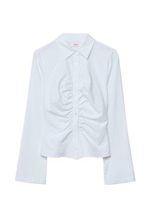 Bela dolga srajca z gumbi in ovratnikom s konicami ter naborki vzdolž sprednjega sredinskega dela.