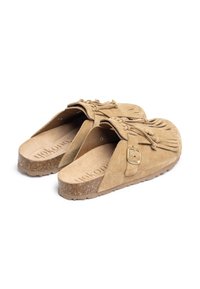 Tan suède instappers met franjes, een gesp-accent en een gekorrelde kurken zool. Het binnenwerk heeft een zachte, beige voetbed.