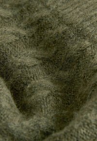 Olivgrüner gestrickter Stoff mit einer weichen Textur und sichtbarem Webmuster, das subtile Farbvariationen und eine leicht flauschige Oberfläche aufweist.