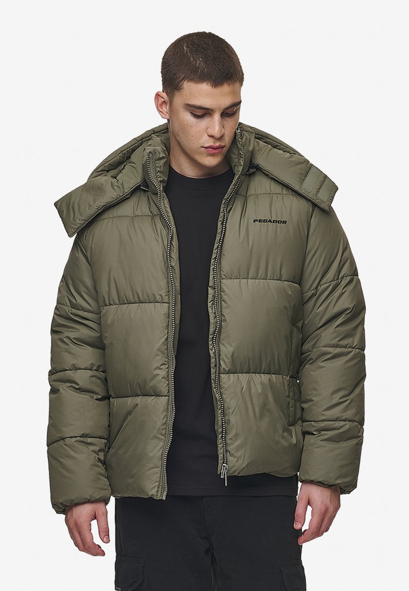 Olive green puffer jacket with a zip front, large hood, and stitched panels. Features logo on chest and thick insulation for warmth.