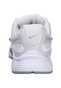 Scarpa sportiva bianca con tomaia in rete, accenti argentati e suola verde menta. Presenta il logo Nike in verde menta sul tallone e un pannello posteriore testurizzato.