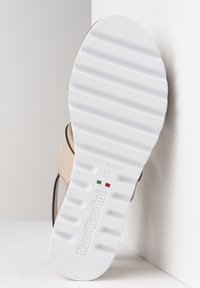 Beige Leder-Schuhsohle mit strukturiertem weißen Gummi. Mit Markenlogo, Größe 37 und dem Prägedruck "Hergestellt in Italien" in den Farben der italienischen Flagge.