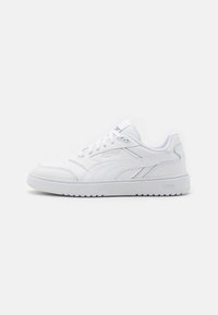 Baskets Puma basses blanches avec fermeture à lacets, semelle texturée et col rembourré, présentées de profil droit sur un fond blanc.