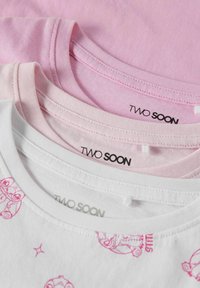 Tričko na obrázku: vrchné je svetloružové, stredné tmavšie ružové, a spodné je biele s svetloružovými kreslenými vzormi. Všetky majú okrúhle výstrihy a visačky.