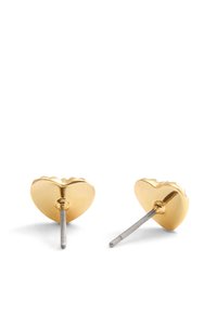 Gyllene hjärtformade studsörhängen med scalloped kant och silverfästen, med en slät, reflekterande yta.