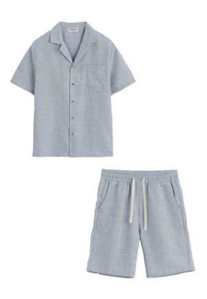 Chemise bleu clair à manches courtes avec boutons, poche poitrine, et short assorti à cordon en tissu doux et structuré.
