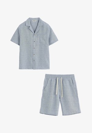 Chemise bleu clair à manches courtes avec boutons, poche poitrine, et short assorti à cordon en tissu doux et structuré.