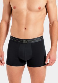 Czarne bokserki wykonane z rozciągliwego, miękkiego materiału. Posiadają pasek z logo CR7 oraz delikatne kontrastujące paski. Dopasowany krój.