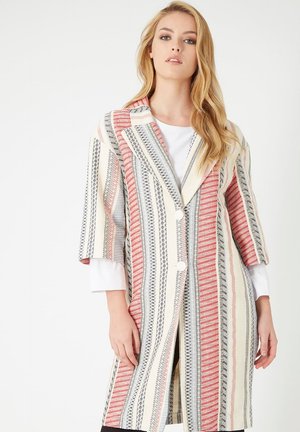 Abrigo tejido a rayas en rojo, gris y crema con cuello entallado, mangas tres cuartos y botones frontales. La tela texturizada presenta patrones geométricos.