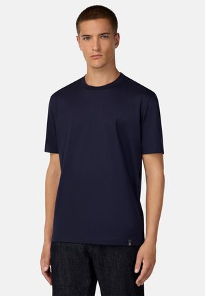 Camiseta de manga corta color azul marino hecha de una tela suave. Presenta un escote redondo y un pequeño logotipo cerca del dobladillo.
