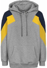 Sweat à capuche gris avec une grande poche avant, présentant des accents diagonaux bleu marine et jaunes sur les épaules. Cordon de serrage à la capuche, texture douce.