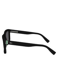 Ochelari de soare negri cu un cadru gros, lentile gri și accente verzi și albe pe brate. Prezintă un sistem de prindere din metal pentru durabilitate.