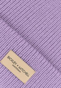Gehaakte lavendel beanie met ribbelstructuur en een omgevouwen rand. Voorzien van een beige label met "BICKLEY + MITCHELL AMSTERDAM" in zwart gedrukt.