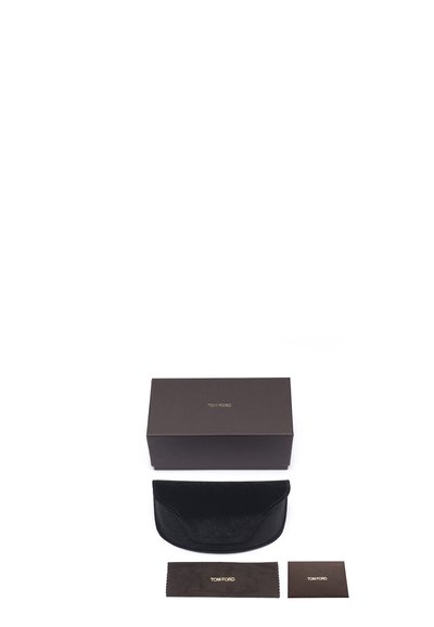 Custodia per occhiali in velluto nero con forma curva, accompagnata da una scatola marrone scuro, un panno per la pulizia e una scheda informativa con testo dorato.