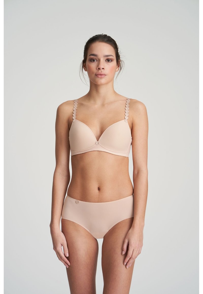 Nude-colored bra with lightly padded cups, scalloped strap detail, and decorative center accent; matching high-waisted brief.
