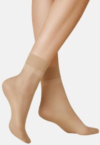 Beige Knöchelsocken aus durchscheinendem Nylon mit glatter Textur, ausgestattet mit einem breiten elastischen Bund an der Oberseite für einen sicheren Sitz.