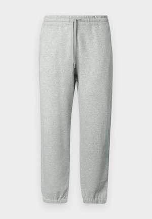 Pantaloni della tuta grigio chiaro realizzati in tessuto morbido, con vita elastica e cordino, gamba affusolata e polsini a costine alle caviglie.