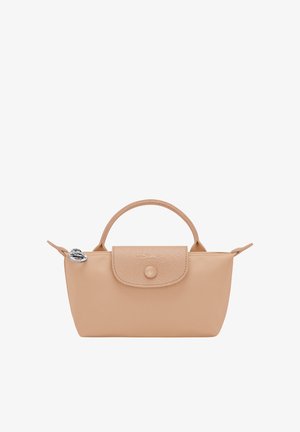 Small beige handbag with rounded handle, flap with button closure, and silver round charm on zipper pull.