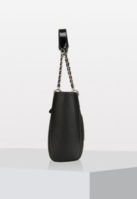 Sac à main en cuir noir avec bandoulière en chaîne argentée et poignée en cuir noir, positionné debout sur une surface blanche sur fond uni.