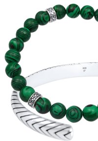 Bracciale in malachite verde con perle rotonde con strisce nere, accentuato da una banda argentata con motivo a zigzag inciso.