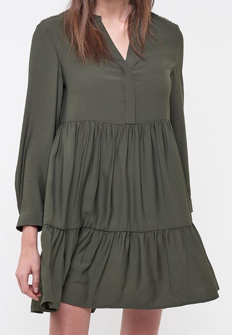 Abito lungo verde oliva, a maniche lunghe, con scollatura a V e orlo a balze stratificate. Realizzato in un materiale morbido e fluido con una vestibilità comoda.