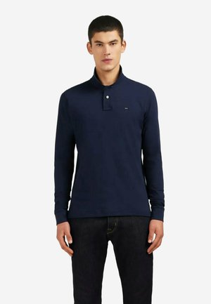 Polo à manches longues bleu marine avec col, comprenant une patte de boutonnage à deux boutons et un petit logo sur la poitrine. Fabriqué en tissu lisse.