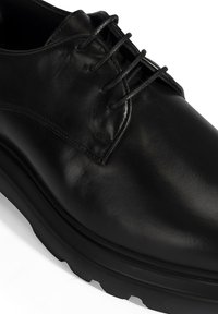 Schwarze Leder Schnürschuhe mit einer glatten Oberseite, runder Zehenform und leichter, strukturierter Sohle. Verfügt über dezente Stichdetails.