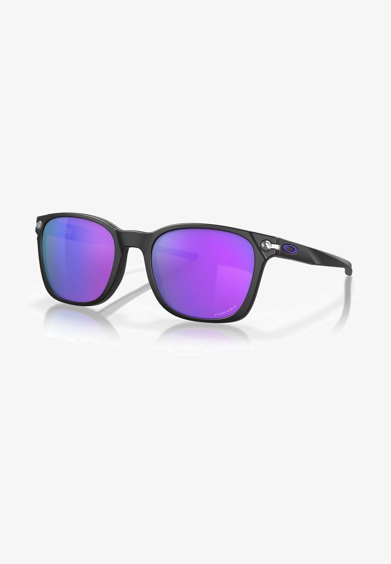 Gafas de sol negras con montura cuadrada y lentes degradados en morado. Presenta un pequeño logo en las patillas y un acabado elegante y brillante.