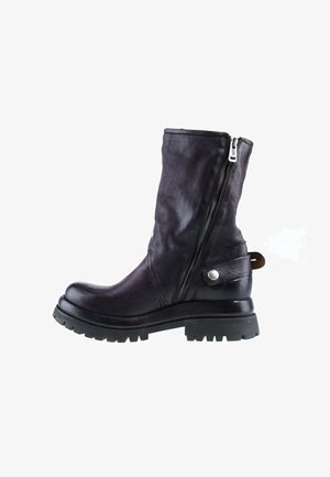 Botte mi-mollet en cuir noir avec fermeture éclair latérale, détail de bride à boucle, semelle épaisse à crampons et bout rond, vue de côté extérieur.