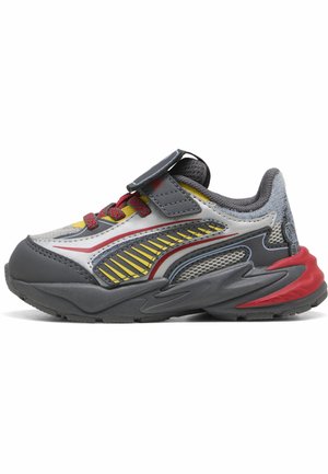 Scarpa da ginnastica grigia con dettagli rossi e gialli, lacci rossi, pannelli in mesh e cinturino in velcro su sfondo bianco.