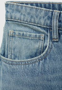 Lichtblauwe denim jeans met een zichtbare achterzak, gele stiksels en een lichte textuur die kenmerkend is voor denimstof.
