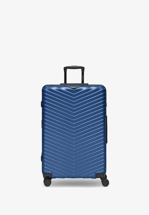 Maleta rígida azul con un patrón de chevron, cuatro ruedas giratorias y un mango telescópico negro extensible.