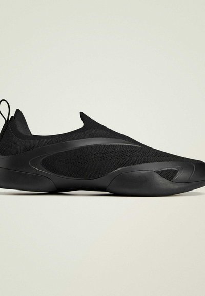 Black athletic shoes with a knit upper, seamless design, and rubber soles. Features a raised back and minimal accents for a streamlined look.