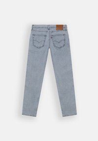 Light blue denim jeans with a straight leg design, featuring two back pockets and a brown leather patch at the waistband.