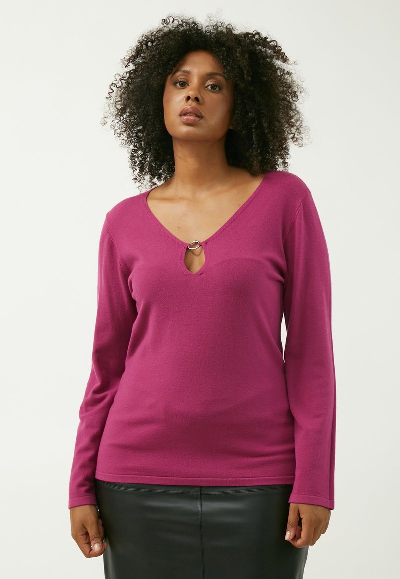 Fuchsia langærmet top med V-hals og en cirkulær nøglehulldetalje, lavet af blødt stof, med en glat tekstur og tætsiddende design.