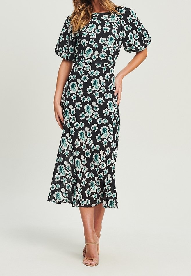 Robe noire à fleurs avec des motifs teal et blancs, manches courtes bouffantes, corsage ajusté et jupe midi fluide. Tissu léger et silhouette féminine.